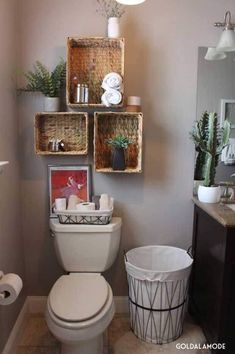 a white toilet sitting inside of a bathroom next to a wooden shelf filled with baskets