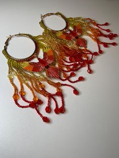 Beautiful Red, orange, and yellow seed bead Phoenix hoop earrings. Festive Multicolor Beaded Hoop Earrings, Unique Beaded Hoop Jewelry, Rainbow Beaded Dangle Hoop Earrings, Festive Beaded Hoop Earrings, Festive Beaded Hoop Earrings With Round Beads, Yellow Hoop Earrings For Festival, Adjustable Orange Hoop Earrings, Bohemian Red Hoop Earrings With Colorful Beads, Bohemian Yellow Hoop Earrings