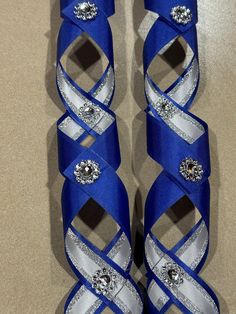 two pairs of blue shoes with silver ribbons