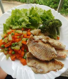 a white plate topped with meat and veggies on top of a window sill