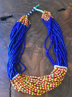 "Gorgeous vintage African glass trade bead statement necklace. It has 20 strands of glass trade beads with stunning cobalt blue, red, and yellow colors. Unique clasp featuring turquoise color beads. Necklace Measures 25\"." Artisan Blue Beaded Necklaces For Festivals, Handmade Blue Beaded Necklaces For Festivals, Festival Blue Beaded Necklaces With Colorful Beads, Blue Beaded Necklaces For Festivals, Traditional Blue Beaded Necklaces With Colorful Beads, Hand-strung Multicolor Jewelry For Festivals, Hand-strung Multicolor Festival Jewelry, Artisan Multicolor Multi-strand Beads, Multicolor Hand-strung Jewelry For Festivals