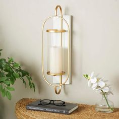 Mount this gold and white sconce on a corner wall or next to a modern art piece to instantly enrich your space with a soft glow. Can hold 1 pillar candle, not included. This item ships in 1 carton. Can be hung vertically using the keyholes; nails and screws not included. Suitable for indoor use only. This item ships fully assembled in one piece. This is a single gold colored candle sconce. Glam style. Material: Metal. Resin Box, Wall Candle, Coloured Candles, Candle Plate, Corner Wall, Modern Wall Sconces, Glam Style, Wall Candles, Wall Light Fixtures