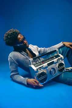 a man laying on the ground with a boombox