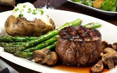 steak, asparagus and mushrooms on a white plate