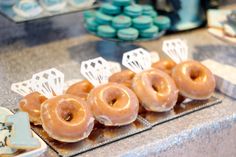 several donuts are arranged on a tray in front of other pastries and desserts