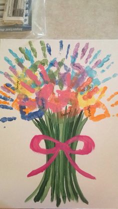 a bouquet of flowers is painted with handprints on a piece of white paper