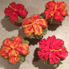 four red and orange flowers sitting on top of a counter