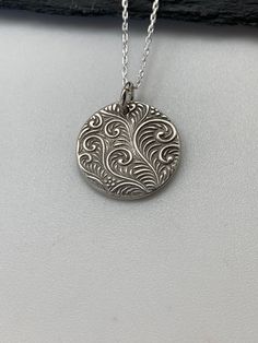 This unique tiny circle silver necklace has been entirely handmade using .999 fine silver. It has been cut from fine silver precious metal clay, textured, fired and oxidized. The pendant hangs from a sterling silver diamond cut cable chain. This fine silver pendant features an embossed textured feather pattern on one side of the pendant and is reversible to a completely different embossed swirly leaf pattern on the reverse side. Pendant size: approximately 1/2 x 1/2 inches Chain length: adjustab Jewelry Layering Necklace, Jewelry Layering, Silver Metal Clay, Moon Necklace Silver, Silver Bar Necklace, Metal Clay Jewelry, Layered Necklaces Silver, Pendant Necklace Silver, Precious Metal Clay