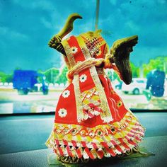 a red and yellow dress with an umbrella in the backgroung is sitting on top of a table