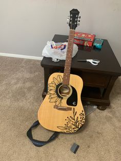 a guitar sitting on the floor next to a table