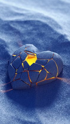 a rock that is sitting in the snow with a yellow light on it's side