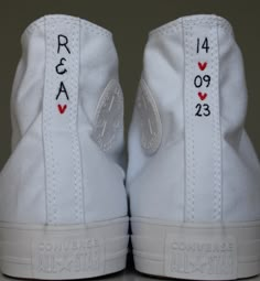 a pair of white sneakers with red and black hearts on them, both have the names of each shoe