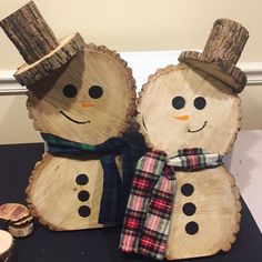 two wooden snowmen with hats and scarfs