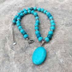 This gorgeous turquoise magnesite beaded pendant necklace is sure to be the perfect addition to your jewelry box!  The oval pendant is 20mm wide x 30mm long (25mm is one inch), and is on a sterling silver bail.  The beaded chain features a mixture of turquoise magnesite beads, mosaic magnesite beads, silver hematite beads and stainless steel flower accent caps.  Secured with a stainless steel lobster clasp, this necklace also has a stainless steel extender chain making it adjustable 1-1/2". Desi Turquoise Necklace With Gemstone Beads And Round Pendant, Turquoise Necklaces With Gemstone Beads, Turquoise Necklace With Round Gemstone Beads Pendant, Turquoise Beaded Necklace With Round Pendant Gift, Turquoise Necklaces With Round Gemstone Pendant, Turquoise Pendant Beaded Necklace With Gemstone Beads, Turquoise Beaded Necklace With Round Pendant, Turquoise Oval Beads Jewelry As A Gift, Turquoise Necklace With Oval Gemstone Beads As A Gift