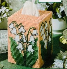 an image of a tissue box with flowers on the front and side, made out of plastic beads