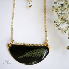 Our Shield Necklace is made from a brass half circle layered with a black background. The preserved green fern contrasts against the background giving this piece a modern and chic style. Also available in our elegant shimmery Midas finish. The Fern is a symbol of sincerity. Pendant hangs from a gold plated chain. Choose from a 26" or 30" length and either plain or satellite chain. Materials are tarnish resistant. However, see our care section for info on keeping your jewelry beautiful. Ships in Shield Necklace, Artisan Necklace, Jewelry Beautiful, Half Circle, Gold Plated Chains, Jewelry Gift Box, Fern, Black Background, Jewelry Gift