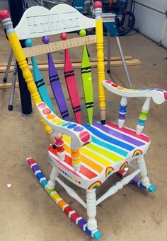 a colorful wooden rocking chair sitting on top of a floor