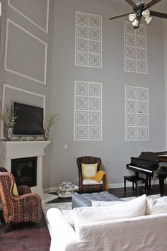 a living room filled with furniture and a flat screen tv mounted to the wall next to a fireplace