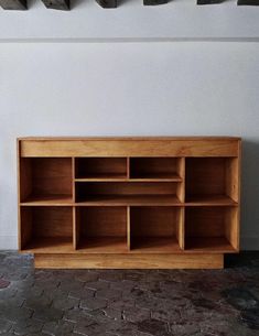 a wooden shelf sitting on top of a brick floor