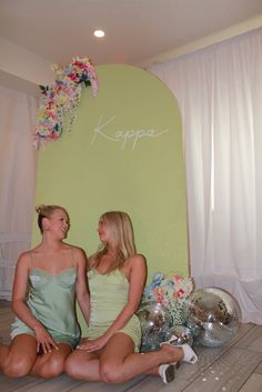 two women sitting next to each other on the floor