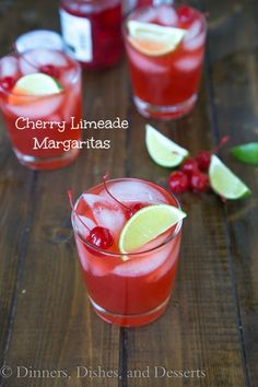 cherry limeade margaritas are served in glasses with cherries and lemon wedges