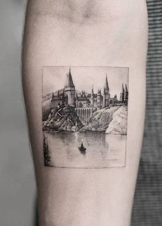 a black and white photo of a castle on the side of a man's arm