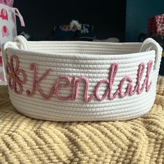 a white basket with pink lettering on it