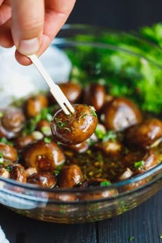 a person dipping some food into a bowl