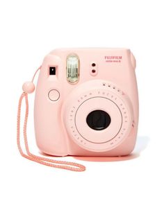 a pink camera sitting on top of a white floor next to a string attached to it