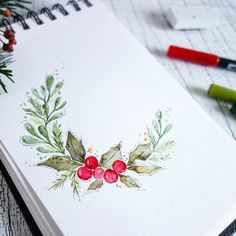 a watercolor christmas card with holly and berries on it, surrounded by crayon markers