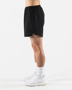 a man in black shorts and white socks is standing with his hands on his hips