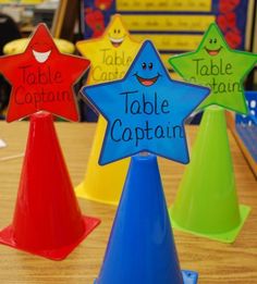 three star shaped plastic table top hats with the words table captain written on each one