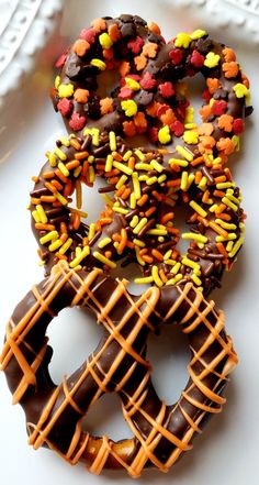 two donuts with chocolate frosting and sprinkles are on a plate