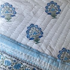 the blue and white bedspread has flowers on it