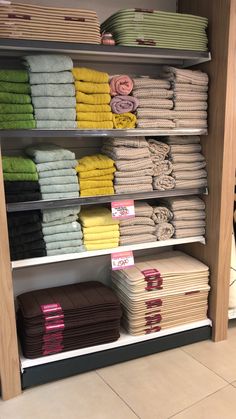 towels are stacked on shelves in a store