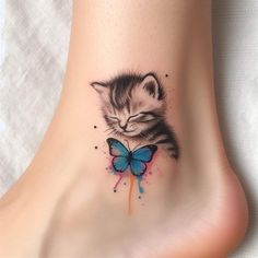 a small kitten with a blue butterfly on its foot