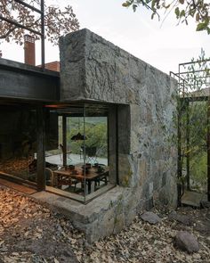 an outdoor dining area in front of a stone building with glass walls and doors on the outside