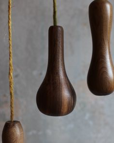 three wooden objects hanging from strings on a wall