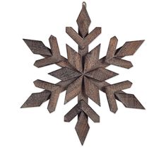 a wooden snowflake hanging on a white wall