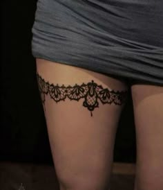 a woman's thigh with a tattoo on the bottom and an intricate lace design