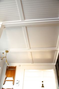 the ceiling is white and has wooden paneling on it's sides, along with a light fixture