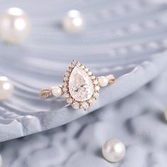 a close up view of a ring with pearls on the surface and in the background