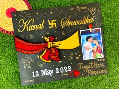 a graduation card with a photo on it laying in the grass next to a straw hat