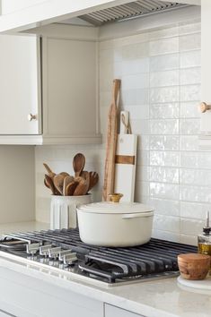 a kitchen stove with utensils and wooden spoons on it