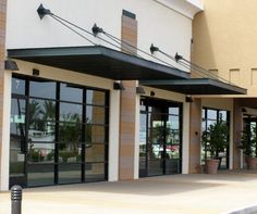 an empty parking lot in front of a building with lots of glass doors and windows