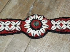 "Vintage Ladakh Belt~ Coral Red Seed Bead, Black Seed Bead,Cowry Shells, Turquoise Brass Center Bead, Statement Belt, Southwest Style Note: scale of 1-10 I give this an 8.5 - it is missing about 10-12 black beads on the bottom the center oval (see photos) there is some wear on the fabric on back side, small holes. See Photos for defects and size. The strings measure 18 3/4 and the other one 21\" - they are not even. Email me with any questions PRIOR to purchase ❀---✿--❀---✿---❀See policies❀---✿- Cowry Shell, Statement Belt, Texas City, Black Seed, Southwest Style, Coral Red, Suspender Belt, Black Beads, Seed Bead