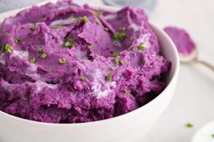 a white bowl filled with purple mashed potatoes