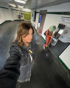 a woman is taking a selfie with her cell phone in an underground parking garage