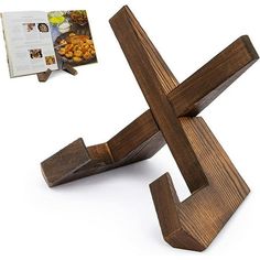 the wooden cross is next to an open book on a white surface with food in it