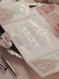 the wedding stationery is laid out on top of the table with silverware and flowers